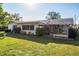 Well-maintained backyard with lush green grass, mature landscaping, and sunroom attached to the home at 807 62Nd W St, Bradenton, FL 34209