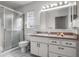 Bathroom with a walk-in shower featuring glass doors, tile floors and vanity with a large mirror at 807 62Nd W St, Bradenton, FL 34209