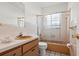 Well-lit bathroom with a shower-tub combo featuring sliding glass doors and a sink with cabinets at 807 62Nd W St, Bradenton, FL 34209