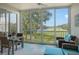 Bright sunroom with wicker furniture, offering tranquil golf course views at 8750 Olde Hickory Ave # 9205, Sarasota, FL 34238