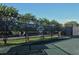 Tennis court with surrounding trees and walking path at 8750 Olde Hickory Ave # 9205, Sarasota, FL 34238