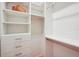 Bright, walk-in closet features custom white built-ins, drawers, shelving, and metal clothing rods at 8818 29Th E St, Parrish, FL 34219