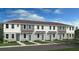Modern townhome exterior with gray and white siding, and teal doors at 8958 Daybreak St, Sarasota, FL 34241