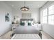Lovely bedroom with a gray upholstered bed and elegant chandelier at 9985 Key Haven Rd, Seminole, FL 33777