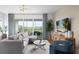 Living room with L-shaped sectional and sliding glass doors to balcony at 9985 Key Haven Rd, Seminole, FL 33777