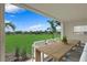 Spacious patio with wooden dining table and chairs, overlooking a lush lawn at 9985 Key Haven Rd, Seminole, FL 33777