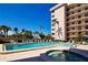 Refreshing pool and hot tub with surrounding lounge chairs at 1001 Benjamin Franklin Dr # 110, Sarasota, FL 34236