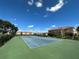 Well-maintained tennis court with green surface and surrounding hedges at 1010 Villagio Cir # 207, Sarasota, FL 34237