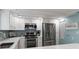 Modern kitchen with stainless steel appliances and a blue accent wall at 1215 S Portofino Dr # 108, Sarasota, FL 34242