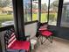 Sunroom with laminate flooring, two patriotic folding chairs, and backyard view at 1318 56Th W St # 1318, Bradenton, FL 34209