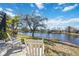 Beautiful backyard featuring serene lake view and white rocking chairs on patio at 14116 Nighthawk Ter, Lakewood Ranch, FL 34202