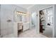 Bathroom featuring tiled floors, glass enclosed shower, white vanity, and doorway to bedroom at 14116 Nighthawk Ter, Lakewood Ranch, FL 34202