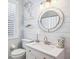 Modern bathroom featuring shiplap walls, floating shelves, and a round mirror above the vanity at 14116 Nighthawk Ter, Lakewood Ranch, FL 34202