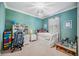 Bedroom featuring a desk area, neutral carpet, and vibrant teal walls at 14116 Nighthawk Ter, Lakewood Ranch, FL 34202