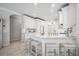 This open kitchen features a large island with seating, custom white cabinets, and modern stainless appliances at 14116 Nighthawk Ter, Lakewood Ranch, FL 34202