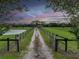 Gravel driveway with black fencing leading to a home at sunset at 15409 Waterline Rd, Bradenton, FL 34212