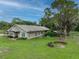 Single-story home with tree-lined yard, tree house, and fire pit at 15409 Waterline Rd, Bradenton, FL 34212