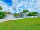 Two-story house with palm trees and a lush green lawn at 18652 Ohara Dr, Port Charlotte, FL 33948