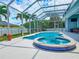 Inviting screened-in pool and spa with outdoor entertaining space at 18652 Ohara Dr, Port Charlotte, FL 33948