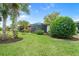 Landscaped backyard featuring a screened porch and lush greenery at 19066 Mangieri St, Venice, FL 34293