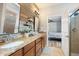 Double vanity bathroom with wood feature wall, and view of bedroom at 19066 Mangieri St, Venice, FL 34293