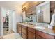 Bathroom with double vanity, walk-in shower, and wood feature wall at 19066 Mangieri St, Venice, FL 34293