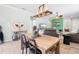 Bright dining room featuring a rustic wooden table, chandelier, and modern artwork at 19066 Mangieri St, Venice, FL 34293