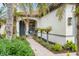 Welcoming front entry with a hanging chair, lush greenery and brick walkway at 19066 Mangieri St, Venice, FL 34293