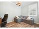 Bright home office with gray sectional sofa and wood-look flooring at 19066 Mangieri St, Venice, FL 34293