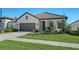 Single-story home with a gray garage door and nicely landscaped front yard at 209 Brindisi Cir, Nokomis, FL 34275