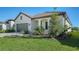 Single-story home showcasing a gray garage door and lush landscaping at 209 Brindisi Cir, Nokomis, FL 34275