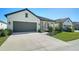 One-story house with gray garage door and well-manicured lawn at 209 Brindisi Cir, Nokomis, FL 34275