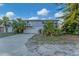 Two-story house with attached garage and tropical landscaping at 210 Willow Ave, Anna Maria, FL 34216