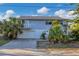 Two-story house with attached garage, palm trees, and a spacious driveway at 210 Willow Ave, Anna Maria, FL 34216