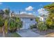 Two-story house with attached garage and tropical landscaping at 210 Willow Ave, Anna Maria, FL 34216