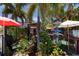 Tropical outdoor patio with seating, plants, and whimsical decor at 210 Willow Ave, Anna Maria, FL 34216