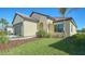 Exterior view of the house, showing a nicely landscaped yard with palm trees at 221 Brindisi Cir, Nokomis, FL 34275