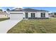 Single-story home with a light gray exterior and teal door at 3015 Brockton St, North Port, FL 34286