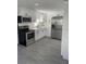 Modern kitchen with white cabinets, stainless steel appliances, and grey vinyl flooring at 3611 3Rd S Ave, St Petersburg, FL 33711