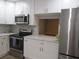 Modern kitchen features white cabinets, stainless steel appliances, and granite countertops at 376 Oak Hill Dr # 36, Sarasota, FL 34232