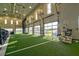 Indoor turf area with large garage doors and equipment at 4337 Sunmill Ct, Lakewood Ranch, FL 34211