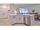 White kitchen island with quartz countertop, stainless steel dishwasher, and black faucet at 4337 Sunmill Ct, Lakewood Ranch, FL 34211