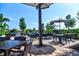 Relaxing outdoor patio area with tables, chairs, and umbrellas at 4337 Sunmill Ct, Lakewood Ranch, FL 34211