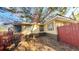 Side view of a house with a red fence and landscaping at 4352 17Th S Ave, St Petersburg, FL 33711