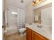 Bright bathroom with tub shower, vanity, and wood cabinets at 4590 Oakley Rd, North Port, FL 34288