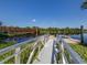 Aluminum walkway to a wooden dock, with a metal bridge over calm water at 4590 Oakley Rd, North Port, FL 34288