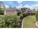 Tan house with gray roof, blue door, and landscaped yard at 4590 Oakley Rd, North Port, FL 34288