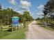 Entrance to Deer Prairie Creek Preserve with a gravel road and gate at 4590 Oakley Rd, North Port, FL 34288