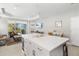 Modern kitchen with white cabinets, center island, and view into the adjacent living room at 4649 Willow Bend Ave, Parrish, FL 34219