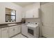 Laundry room with white cabinets, washer, dryer, and a utility sink at 4839 Pastel Ct, Sarasota, FL 34240